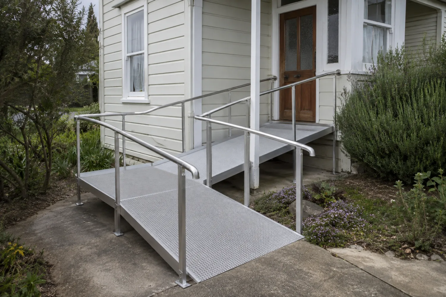 Custom fabricated aluminium wheelchair access ramp with handrails and non-slip decking at a New Zealand home, made by Specialised Stainless