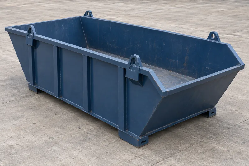 A painted steel skip bin with reinforced sides, lifting attachment supports and a visible base