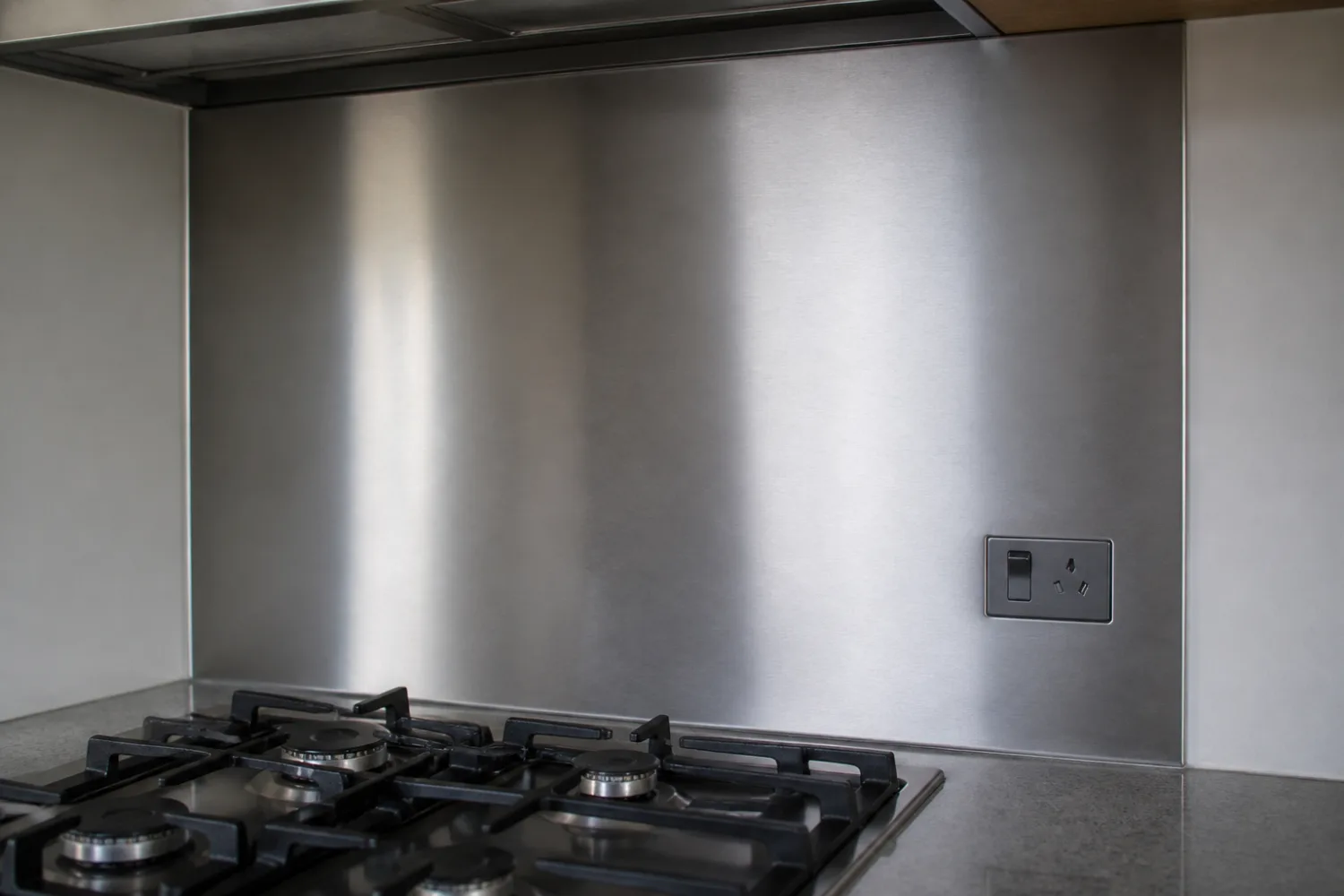 Brushed stainless steel splashback panel fitted behind a cooktop, fabricated by Specialised Stainless