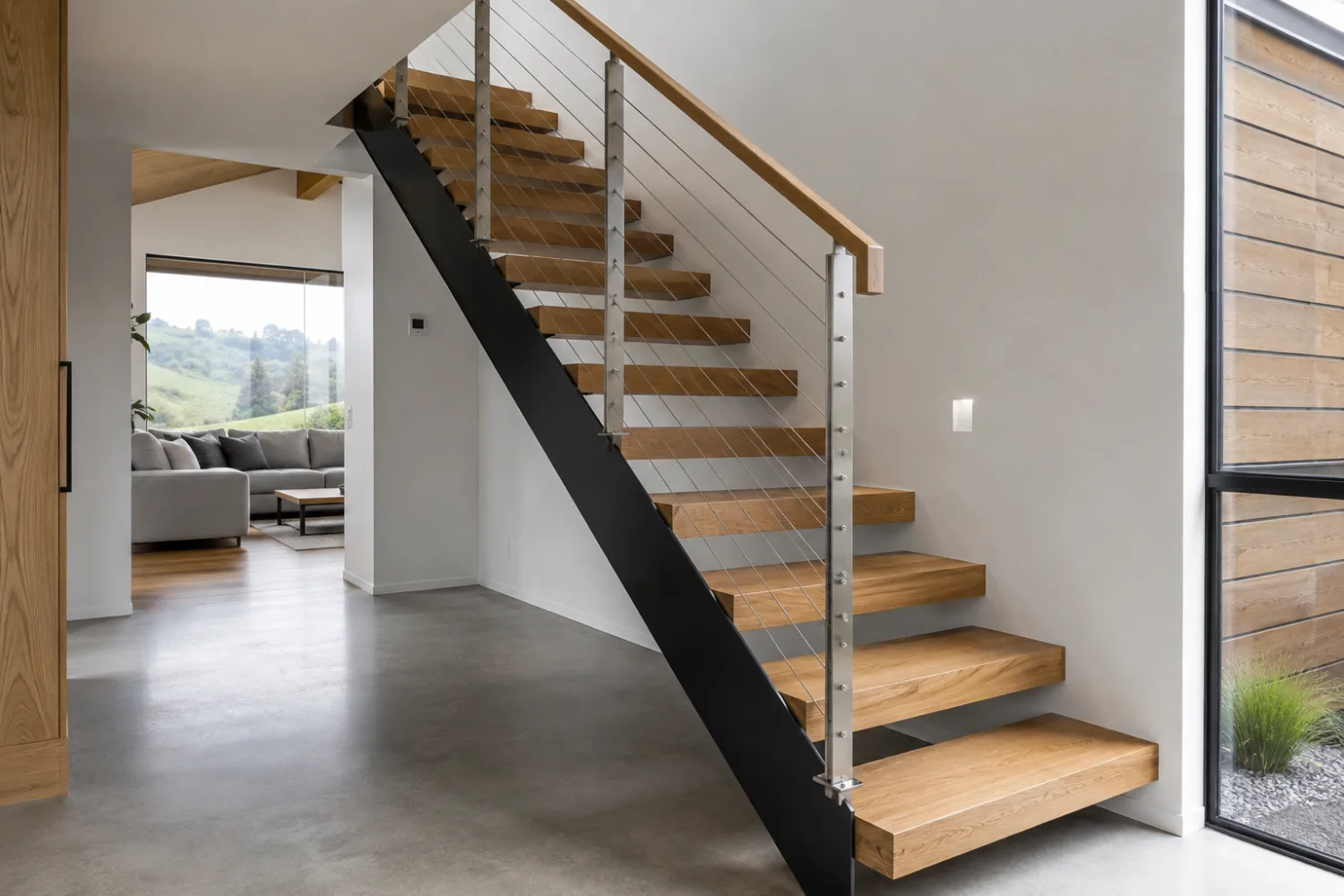 Custom fabricated steel mono-stringer staircase with timber treads and stainless wire balustrade, made by Specialised Stainless